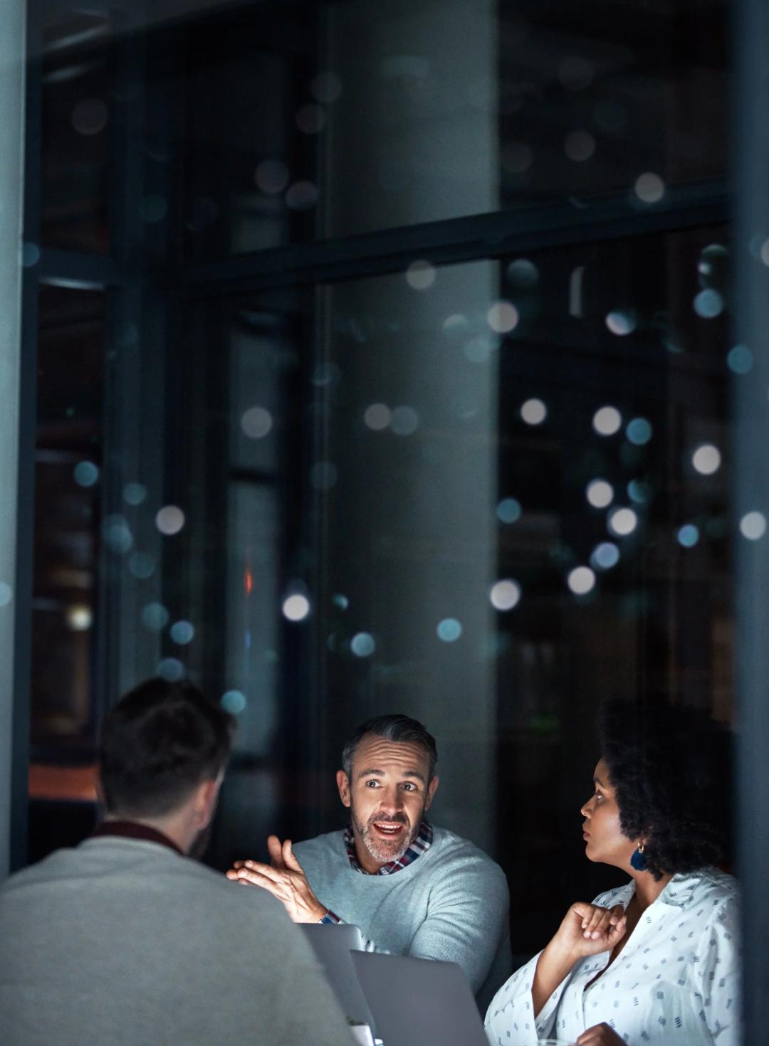 Three people working at an office at night